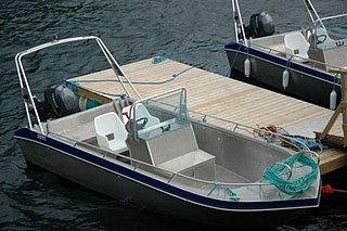 Angelboot aus Aluminium, direkt an einem Holzsteg in Hälsingland, Schweden, vertäut. Ideal für Angelreisen und Abenteuer auf dem Wasser. Stimmungsvolle Wasserszene, die Vorfreude auf unvergessliche Angelausflüge weckt.