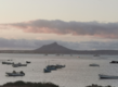 Sonnenuntergang über der Bucht von São Vicente, Kapverden: Boote schwimmen im ruhigen Meer, während der Himmel in sanften Rosa- und Grautönen leuchtet. Im Hintergrund erhebt sich ein beeindruckender Berg. Serene Meereslandschaft.