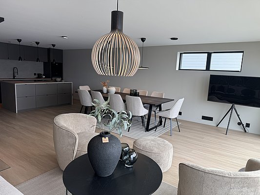 Moderne Ferienwohnung in Südwest-Norwegen mit stilvollem Interieur: Offene Küche, großer Esstisch, gemütliche Sitzecke, elegante Beleuchtung. Ideal für erholsamen Angelurlaub und unvergessliche Abenteuer. Perfekt zum Entspannen nach einem erfolgreichen Angelausflug.