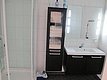 Modernes Badezimmer im Nordland-Stil, Norwegen: Duschkabine, Spiegel mit integrierter Beleuchtung, Waschbecken, dunkles Möbelstück mit Handtüchern. Elegantes, funktionales Design, ideal für Angelabenteuer und Erholung.