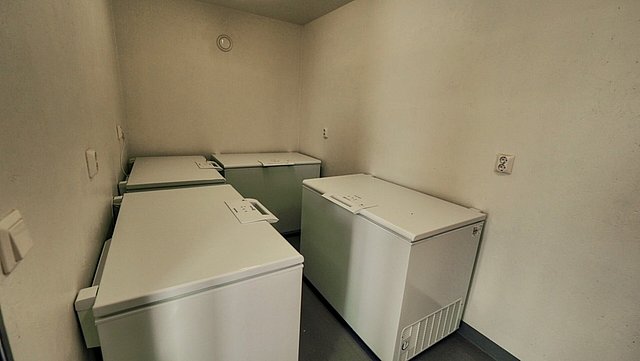 Ein schlichter Raum in Nordland, Norwegen, mit vier weißen Gefriertruhen. Ideal zum Lagern von Fängen nach erfolgreichen Angelreisen im malerischen Skandinavien.
