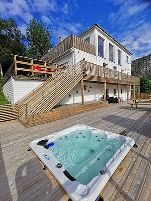 Modernes Ferienhaus in Nord-Norwegen mit weitläufiger Holzterrasse und Hot Tub, perfekter Ort für Angelurlaub. Idyllische Lage mit beeindruckender Naturkulisse und komfortabler Ausstattung, ideal für entspannte Tage nach erfolgreichen Angelausflügen.