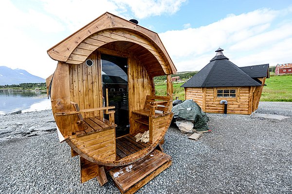 Holz-Saunahütte in Nord-Norwegen, malerisch am Wasser gelegen. Perfekter Ort für Entspannung nach dem Angeln. Rustikales Design ergänzt die natürliche, friedliche Umgebung. Ideal für Erholungssuchende und Angelurlauber, die die beeindruckende Natur genießen möchten.