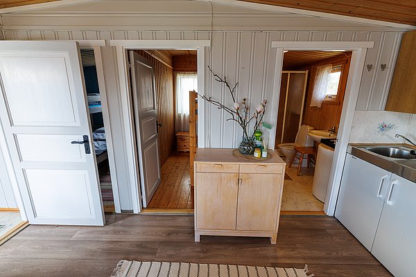Gemütliche Ferienwohnung in Hitra, Norwegen: Holzboden, Badezimmer, Schlafzimmer mit Etagenbett und kleine Küche. Ideal für Angler auf Angelreise. Skandinavischer Charme trifft auf Funktionalität. Perfekt für entspannte Urlaubstage nach erfolgreichen Angelausflügen.