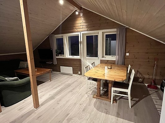 Gemütliche Ferienwohnung in Nord-Norwegen mit Holzvertäfelung, Essbereich und Sofa. Ideal für erholsame Angelreisen. Helle, einladende Atmosphäre mit skandinavischem Flair. Perfekter Rückzugsort nach einem erfolgreichen Tag am Wasser.