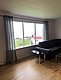 Gemütliches Wohnzimmer in Nord-Norwegen mit Panoramafenster, stilvollem Sofa und Blick auf das Meer und bunte Häuser. Perfekter Rückzugsort nach einem erlebnisreichen Angeltag. #Angelurlaub #NordNorwegen #Entspannung