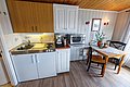 Gemütliche Küchenzeile in einer Ferienunterkunft in Hitra, Norwegen. Ausgestattet mit Herd, Spüle, Mikrowelle, Kaffeemaschine und Esstisch. Perfekt für Angler, die Entspannung und Abenteuer suchen. Ideal für einen erholsamen Angelurlaub.