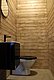 Modernes Badezimmer in Nordland, Norwegen: Holzverkleidete Wände, Waschbecken mit Spiegel, Toilette. Skandinavisches Design vereint natürliche Materialien und schlichtes Ambiente. Ideal für erholsame Momente nach einem aufregenden Angelausflug.