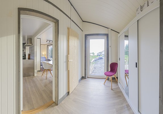 Gemütliches, modernes Interieur einer norwegischen Ferienunterkunft in Nordland. Helles Holz, stilvolle Möbel, große Fenster mit Aussicht. Ideal für Angelreisen und Entspannung. Skandinavisches Design trifft auf Komfort und Naturverbundenheit.