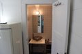 Kompaktes Badezimmer in Südwest-Norwegen: Elegante Steinschale auf weißem Waschtisch, dezente Fliesen, moderner Spiegel. Perfekt für erholsame Angelurlaube in gemütlicher Umgebung.