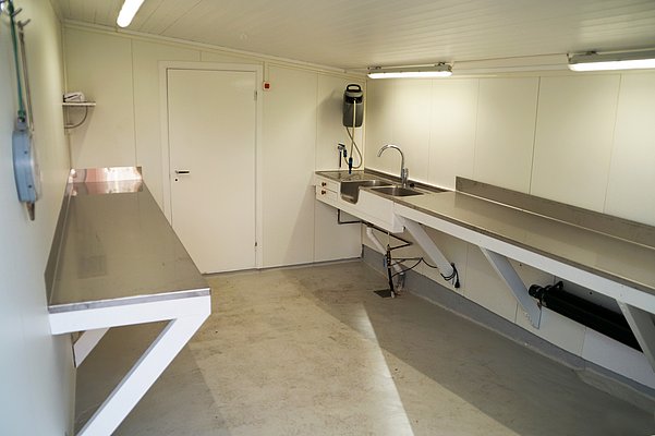Hochmoderne Fischverarbeitungsküche in Nord-Norwegen mit großen Edelstahlarbeitsflächen und Spülen. Ideal für Angler zur effizienten Fischbearbeitung nach erfolgreichen Angelausflügen. Perfekte Kombination aus Funktionalität und Komfort für den Angelurlaub.