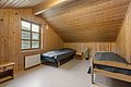 Gemütliches Schlafzimmer in Nordland, Norwegen, mit zwei Einzelbetten und Holzverkleidung. Ideal für Angelreisende, die Komfort und Ruhe suchen. Große Fenster bieten natürliche Lichtdurchflutung und maximale Entspannung. Perfekte Unterkunft für unvergessliche Angelabenteuer.