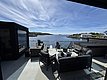Moderne Terrasse mit stilvollen Möbeln bietet atemberaubenden Blick auf norwegische Fjordlandschaft, umgeben von klarem Himmel und ruhigem Wasser. Perfekt für Angelurlaub oder Entspannung in Südwest-Norwegen.