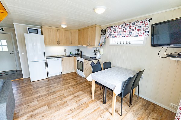 Gemütliche, helle Ferienwohnung in Nord-Norwegen mit moderner Küchenzeile, Esstisch und TV. Ideal für Angelreisen, umgeben von atemberaubender Natur und Fangmöglichkeiten. Perfekt für Entspannung nach einem erfolgreichen Angeltag.