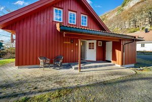 Gemütliches rotes Holzhäuschen in Süd-Norwegen, umgeben von malerischer Landschaft. Perfekt gelegen für einen erholsamen Angelurlaub. Sitzgelegenheiten auf der Terrasse bieten Entspannung nach einem erfolgreichen Angeltag. Ideal für Natur- und Angelfreunde.