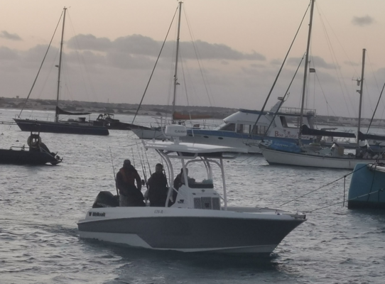 Fischerboot vor Anker im Hafen von São Vicente, Kapverden, umgeben von Segelbooten bei Sonnenuntergang. Ideal für einen Angelurlaub mit exotischem Flair und entspannter Atmosphäre.