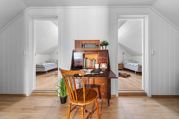 Ein gemütlicher, heller Dachbodenraum in Nord-Norwegen mit einem Holzschreibtisch, zwei Schlafzimmern und moderner Einrichtung. Perfekt für entspannende Angelurlaube in skandinavischem Design. Ideal für Erholung nach einem aufregenden Angeltag.