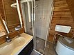 Modernes Bad in gemütlicher Hütte auf Hitra, Norwegen. Holzverkleidung, geräumige Dusche, Waschbecken mit Spiegel. Ideal für Angelurlauber, die Komfort und Naturverbundenheit suchen. Perfekter Rückzugsort nach einem erfolgreichen Angeltag.