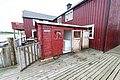 Rotes Holzgebäude in Nordland, Norwegen, direkt am Wasser. Skandinavische Architektur auf hölzernem Steg. Perfekt für Angelurlaube, um die idyllische Küstenlandschaft zu erleben. Entdecke fischreiche Gewässer in traumhafter Umgebung.