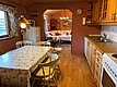Gemütliche Ferienhütte in Hitra, Norwegen: Rustikaler Essbereich mit Holzmöbeln, Blick ins Wohnzimmer, wohnliche Atmosphäre, ideal für erholsamen Angelurlaub. Charmante Einrichtung vereint Tradition und Komfort – perfekter Rückzugsort nach einem erfolgreichen Angeltag.
