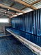 Innenansicht eines hölzernen Schuppens mit Wellblechdach in Hitra, Norwegen. Holzstruktur und Fenster sorgen für rustikalen Charme und Atmosphäre – idealer Ausgangspunkt für Angelreisen und Abenteuer in der Region.