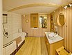 Gemütliches Badezimmer in Nordland, Norwegen: warme Holztöne, moderne Badewanne, runder Spiegel und dekorative Elemente. Perfekte Entspannungsoase nach erlebnisreichen Angelabenteuern. Ideal für Ihren nächsten Angelurlaub im hohen Norden.