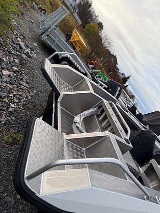 Aluminiumboot auf Kies, Südwest-Norwegen. Ideal für Angelreisen, robust und bereit für Abenteuer. Umgeben von herbstlicher Natur, transportiert auf Anhänger. Perfekte Kombination aus Funktionalität und Naturerlebnis. Ideal für Angelurlaub in Norwegen.