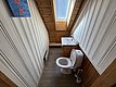 Gemütliches Badezimmer in Hitra, Norwegen: Holzverkleidung, Dachfenster, Toilette und Waschbecken. Perfekt für Angeltouren mit rustikalem Charme. Heller Raum mit praktischen Annehmlichkeiten und warmem Ambiente. Ideal für entspannte Angelurlaube.