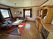 Gemütliches Wohnzimmer in Hitra, Norwegen: Ledersofa, Holztisch, bunte Teppiche und große Fenster mit Aussicht. Ideale Unterkunft für einen Angelurlaub in beeindruckender skandinavischer Umgebung. Entspannt nach einem erfolgreichen Angelausflug erholen.