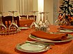Ein stilvoll gedeckter Tisch mit umgedrehten Weingläsern, orangefarbenen Servietten und dekorativen Tellern, bereit für ein elegantes Dinner. Ein stilvoll gedeckter Tisch mit umgedrehten Weingläsern, orangefarbenen Servietten und dekorativen Tellern, bereit für ein elegantes Dinner.