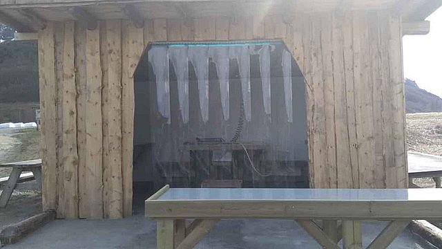 Holzhütte mit Tisch und Schutzvorhang in Nordland, Norwegen. Perfekt als Angelunterkunft oder Basis für Angelreisen. Ruhige Atmosphäre, ideal für Meeresangeln und Outdoor-Abenteuer. Perfekte Grundlage für unvergessliche Angelerlebnisse in Norwegens Natur.