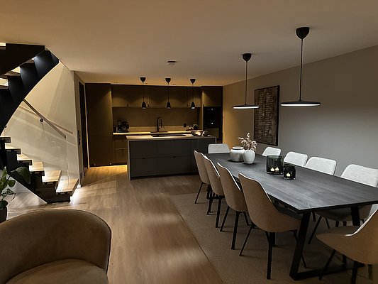 Moderne offene Küche in Südwest-Norwegen: Stilvolles Design mit großzügigem Esstisch, eleganten Hängeleuchten und Treppe im Hintergrund, ideal für gemütliche Angelurlaubsabende.
