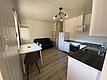 Gemütliche Ferienwohnung in Nord-Norwegen: Moderne Küche mit Herd, Kühlschrank und Spüle, angrenzender Essbereich, Sofa zur Entspannung. Perfekt für Angelurlauber, die Komfort und Abenteuer kombinieren möchten. Ideal für erholsame Aufenthalte nach erfolgreichen Angelausflügen.