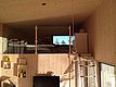 Gemütliche Holzkabine in Nordland, Norwegen, mit Schlafbereich im Loft-Stil. Große Fenster bieten Blick auf Natur; ideal für Angelurlaub. Moderne, minimalistische Einrichtung mit hölzernem Interieur. Perfekt für Abenteuer in skandinavischer Wildnis.