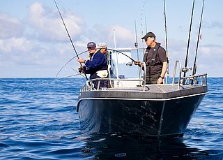 Ein Boot auf dem River Erne in Irland, mit Anglern beim Meeresangeln. Ruhiges, blaues Wasser und klarer Himmel schaffen eine entspannte Atmosphäre für Angelreisen.