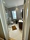 Modernes Badezimmer in Hitra, Norwegen: Elegantes Design mit Glasdusche, weißem Waschtisch, grauen Wänden und Fenster mit Aussicht. Perfekt für entspannte Angelreisen in skandinavischer Umgebung.