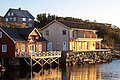Gemütliche Holzcottages am Wasser in Hitra, Norwegen, in warmem Sonnenlicht. Perfekt für Angelurlaube und Naturerlebnisse in malerischer Umgebung. Entdecke die Ruhe und Schönheit der skandinavischen Küstenlandschaft.