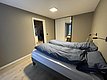 Ein modernes Schlafzimmer mit zwei Einzelbetten, blauer Bettwäsche und eingebautem Kleiderschrank. Einladendes Ambiente in Hitra, Norwegen, ideal für Angelurlaub und Entspannung.