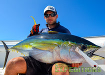 Angler in Tansania präsentiert stolz einen gefangenen Gelbflossenthunfisch auf einem Boot. Der strahlend blaue Himmel und der beeindruckende Fang betonen das Abenteuer des Angelurlaubs in Ostafrika. Perfekt für Sportangeln und unvergessliche Erlebnisse.
