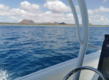 Blick vom Boot auf das blaue Meer vor São Vicente, Kapverden, mit malerischen Vulkanlandschaften und bewölktem Himmel. Ideal für Angelreisen und ein Traumziel für Meerliebhaber und Abenteurer.