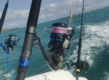Angelruten bei einer Bootsfahrt vor Sao Vicente, Kapverden. Klares Meerwasser, blauer Himmel und ziehende Wolken. Perfekte Bedingungen für Sportfischen und Meeresangeln auf hoher See. Abenteuerliche Angelreise erwartet.