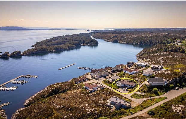 Eine malerische Küstenlandschaft in Südwest-Norwegen mit charmanten Häusern am Wasser, umgeben von Fjorden und grünen Inseln. Perfekt für Angelurlaub und Erholung in beeindruckender, natürlicher Schönheit.