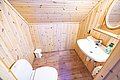 Gemütliches Badezimmer in einer Holzhütte in Nordland, Norwegen. Holzverkleidung, Waschbecken, Toilette und Spiegel. Perfekt für Anglerabenteuer in skandinavischer Naturidylle. Optimaler Rückzugsort nach einem erfolgreichen Angeltag.