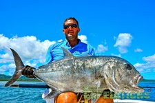 Ein Angler hält einen beeindruckenden, großen Fisch, unter strahlend blauem Himmel auf einem Boot vor der Küste Tansanias. Perfektes Ziel für begeisterte Angler auf der Suche nach Abenteuern und großartigen Fängen.
