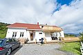 Weißes Holzhaus in Hitra, Norwegen mit rotem Dach, großer Terrasse und ruhiger Lage. Perfekt für entspannende Angelreisen inmitten malerischer Natur. Optimaler Ausgangspunkt für Abenteurer und Erholungssuchende.