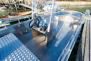 Aluminiumboot mit Steuerstand in Nordland, Norwegen. Perfekt für Angelreisen, bietet das robuste Boot auf dem Wasser starke Stabilität. Ideal für Angler, die das norwegische Angelabenteuer suchen.