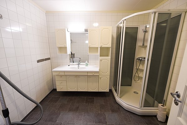 Helles, modernes Badezimmer in Hitra, Norwegen. Ausgestattet mit Duschkabine, Waschbecken und viel Stauraum. Ideal für Angelurlauber, die Komfort und Bequemlichkeit suchen. Attraktive Unterkunft für sorgenfreies Meeresangeln und Entspannung.