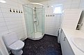Modernes Badezimmer in Nordland, Norwegen: ausgestattet mit Dusche, WC, Waschmaschine und Waschbecken. Helle Fliesen, funktionelles Design – ideal für Angelurlaube. Sauber und komfortabel für einen erholsamen Aufenthalt in der Natur.