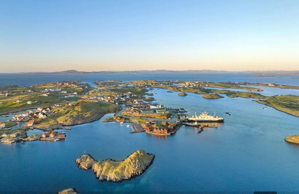 Luftaufnahme von einer Küstenlandschaft mit kleinen Inseln, Gebäuden und einem großen Schiff im Hafen bei Sonnenuntergang. Luftaufnahme von einer Küstenlandschaft mit kleinen Inseln, Gebäuden und einem großen Schiff im Hafen bei Sonnenuntergang.