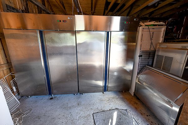 Gewerbliche Edelstahl-Gefrierschränke in einer Holzhütte auf Hitra, Norwegen, optimiert für die Lagerung von frischem Fisch. Ideal für Angler auf Angelreisen. Energieeffiziente Kühlung sorgt für optimale Fischqualität.